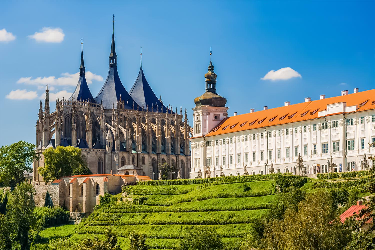 St. Barbara's Cathedral's Gothic spires beside the Jesuit College, above terraced gardens