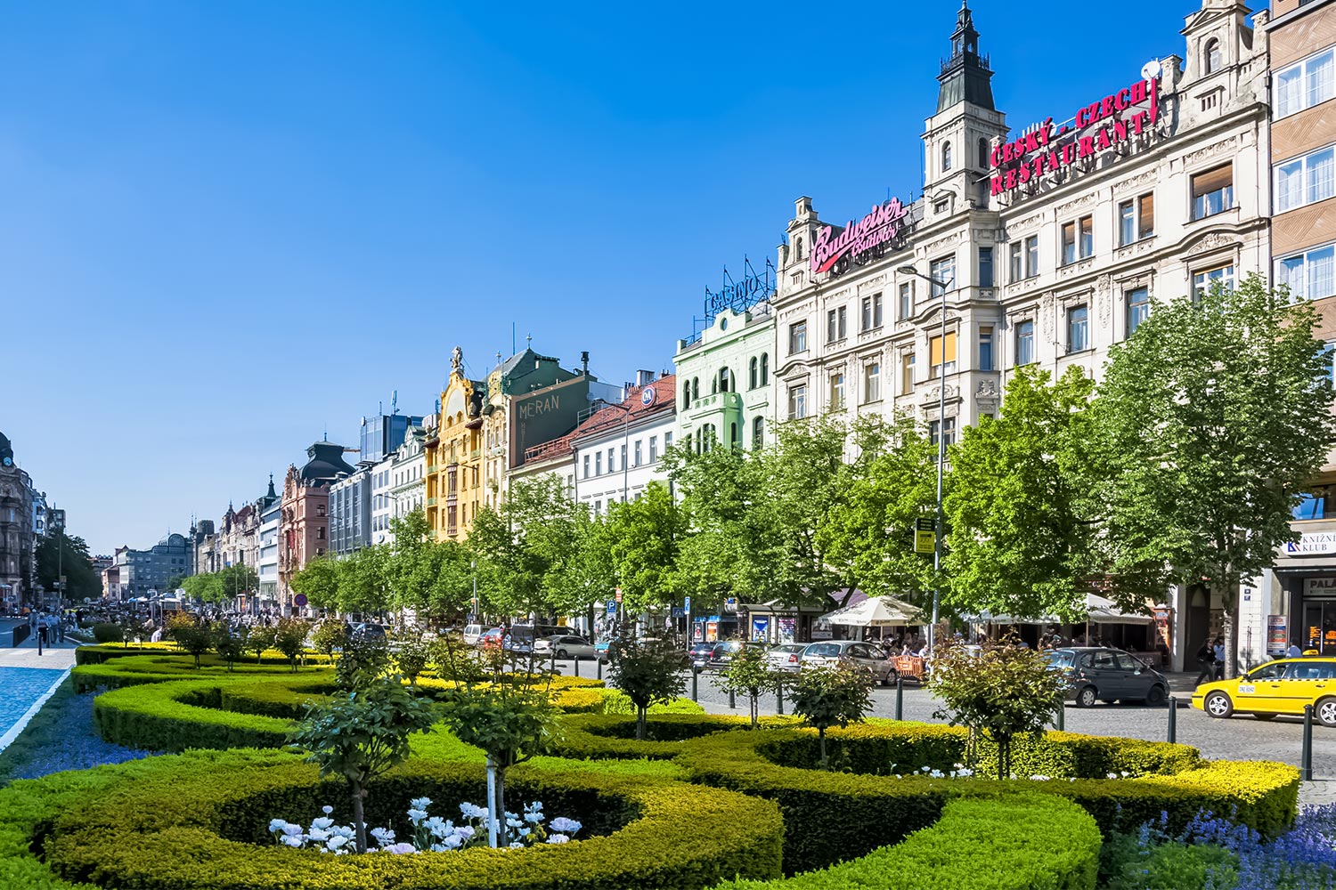 Wenceslas Square's ornamental gardens and Art Nouveau facades on a sunny day